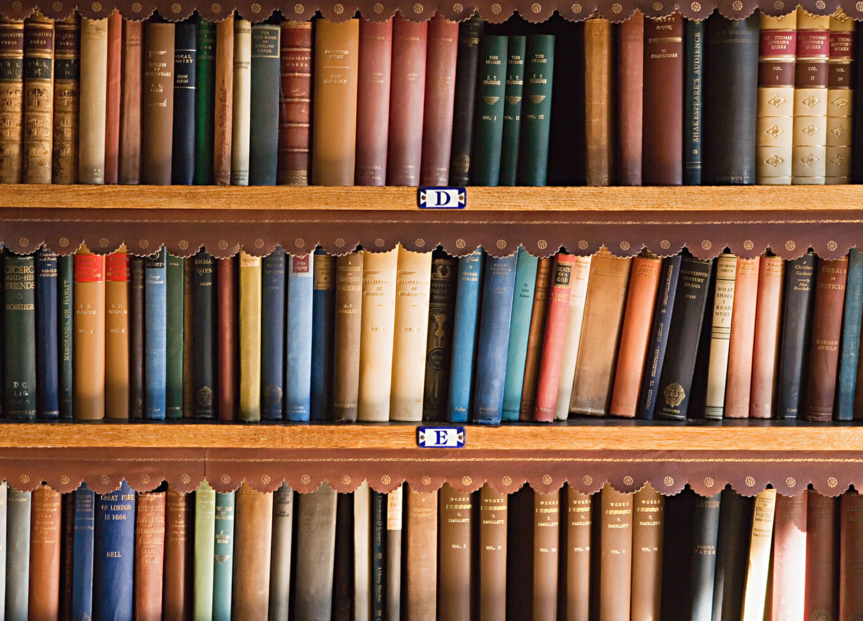 Shelves filled with old, leather-bound books in a library.